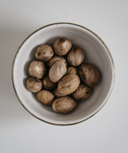 how to use, ground Whole nutmeg, which is the seed of the Myristica fragrans tree encased in a hard shell and characterized by its warm, sweet, and slightly spicy flavor, can be prepared by grating it freshly using a fine grater or microplane to release its potent aroma and enhance its flavor, and it can be used in a variety of culinary applications such as adding a dash to creamy sauces, béchamel, and custards, incorporating into baked goods like pies, cakes, and cookies, seasoning vegetables, meats, and pasta dishes, and infusing beverages like eggnog, mulled wine, and chai tea, thereby offering a fresh and intense spice that elevates both sweet and savory dishes with its complex profile.